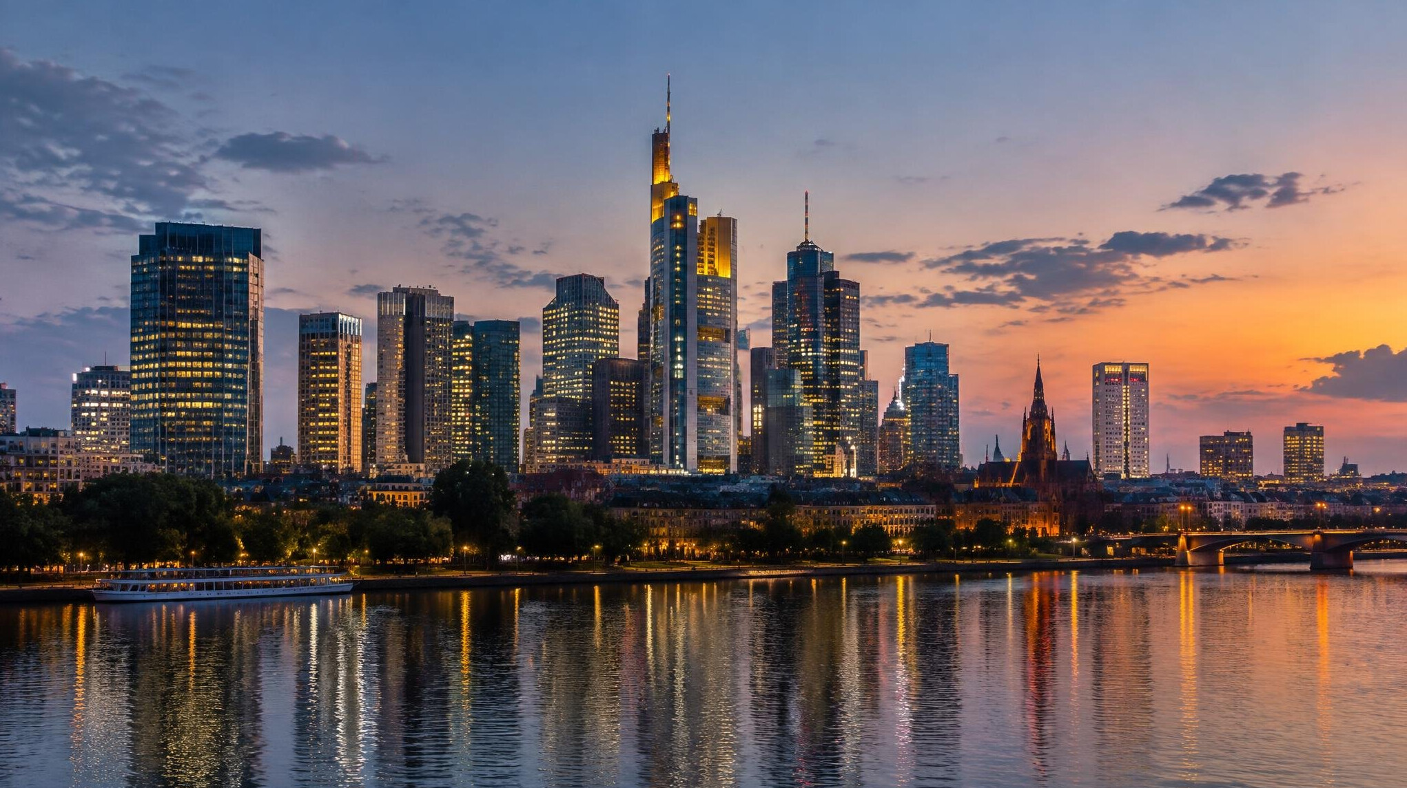 Modern city skyline at dusk with warm lights in the buildings